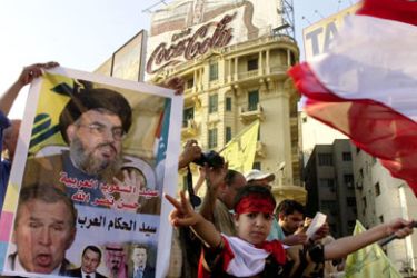 Egyptians wave a Lebanese flag and a poster of Shiite Hezbollah Chief Hassan Nasrallah with a slogan reading "Master of the Arab leaders" during a demonstration