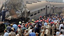 Egyptian onlookers stand at the site of a train crash in Qaliub, about 20 kms (12 miles) north of Cairo, 21 August 2006