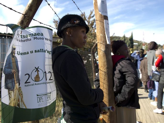 LESOTHO : A woman stands near an election poster in Maseru on May 24, 2012 two days ahead of the southern African state of Lesotho's parliamentary elections