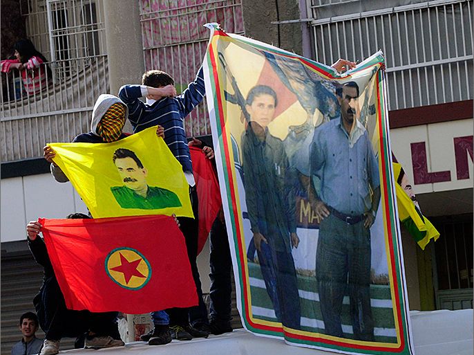 Turkish-Kurdish demonstrators hold a poster, which shows jailed Kurdistan Workers' Party (PKK) leader Abdullah Ocalan (R) with late Kurdish activist Sakine Cansiz, during a protest in Diyarbakir, southeastern Turkey, February 15, 2013. Supporters of the pro-Kurdish Peace and Democracy Party (BDP) held a protest to mark the 14th anniversary of the capture of Ocalan. REUTERS/Stringer (TURKEY - Tags: POLITICS CIVIL UNREST)
