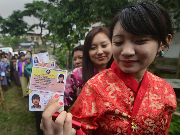 epa03786580 A Bhutanese woman shows her voter ID card while standing in a queue along with others to cast her vote at Bangtsho polling station in Deothang constituency, Samdrupjongkhar district, Bhutan, 13 July 2013. Tens of thousands of people in Bhutan voted 13 July in the second-ever parliamentary elections, which are being seen as a verdict on five years of democracy in the tiny Himalayan nation. EPA/STRINGER