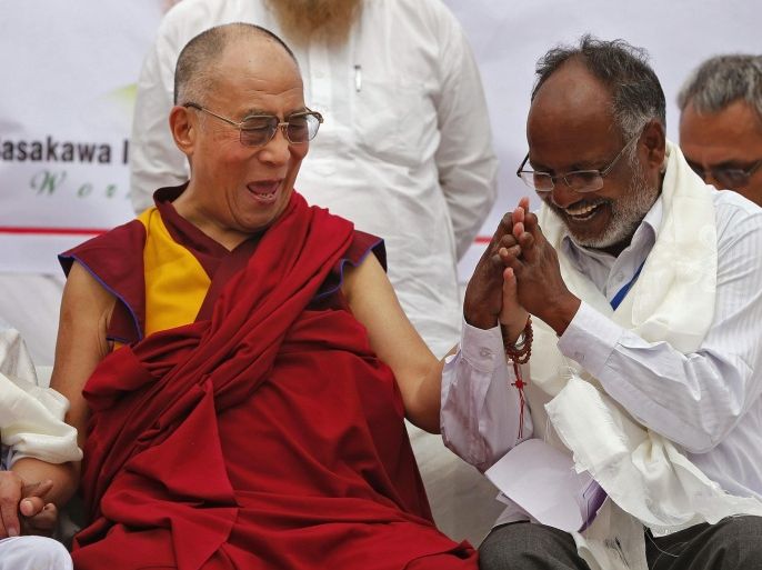 Exiled Tibetan spiritual leader, the Dalai Lama (C) laughs as he holds the hands of leprosy-affected patients during his visit to a leprosy colony in New Delhi March 20, 2014. REUTERS/Adnan Abidi (INDIA - Tags: HEALTH SOCIETY RELIGION)