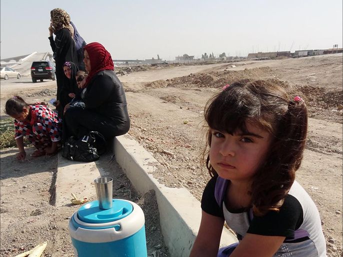 A young Iraqi girl, displaced from the village of Mansuriya in the Diyala province north of Baghdad, where fighting with militant jihadists has been raging, sits on the side of a road on June 27, 2014 as she heads with her family to the ethnically mixed northern Iraqi city of Kirkuk to take refuge. Iraqi Kurdish leader Massud Barzani said there was no going back on autonomous Kurdish rule in Kirkuk and other towns now defended against Sunni militants by Kurdish fighters. AFP PHOTO / MARWAN IBRAHIM