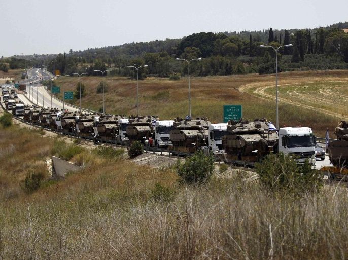 A convoy of Israeli lorries carrying army tanks can be seen on a road leading to southern Israel, at Latrun, near Jerusalem July 12, 2014. Israel pounded Palestinian militants in the Gaza Strip on Saturday for a fifth day, killing nine people including two disabled women according to medics, and showed no sign of pausing despite international pressure to negotiate a ceasefire. In Israel, a Palestinian rocket seriously wounded one person and injured another seven when it hit a fuel tanker at a service station in Ashdod, 30 km (20 miles) north of Gaza. Islamist militants in Gaza warned they would launch rockets at Tel Aviv's main international airport and warned airlines to stay clear. REUTERS/Ammar Awad (ISRAEL - Tags: POLITICS CIVIL UNREST MILITARY CONFLICT)