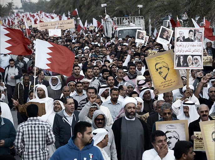 Bahraini protestors hold up their national flag as they take part in an anti-government demonstration in the village of Jannusan, west of the capital Manama, on December 26, 2014. The Sunni-ruled kingdom held parliamentary elections last November that have been boycotted by the main opposition Al-Wefaq movement which calls for democratic reforms. AFP PHOTO / MOHAMMED AL-SHAIKH