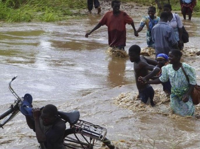 People cross a flooded river in Chikwawa district, some 70 km (43 miles) south of Malawi�s commercial capital Blantyre, January 15, 2008. Floods in southern Africa have displaced thousands of people, drowned livestock and put large numbers of children at risk from life-threatening diseases.