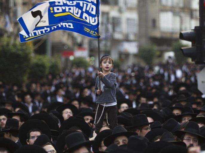 An ultra-Orthodox Jewish boy waves a banner during a rally in support of the United Torah Judaism party in Bnei Brak near Tel Aviv March 11, 2015. Israelis will vote in a parliamentary election on March 17, choosing among party lists of candidates to serve in the 120-seat Knesset. REUTERS/Ronen Zvulun (ISRAEL - Tags: POLITICS ELECTIONS TPX IMAGES OF THE DAY)