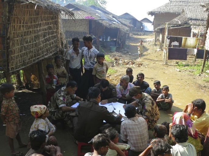 In this Nov. 10, 2012 photo, immigration officers fill out forms during an operation to verify the citizenship of Muslims living in the western Myanmar village of Sin Thet Maw. The government launched the checks on Nov. 8 after unrest broke out in June between ethnic Rakhine Buddhists and Rohingya Muslims they view as foreigners from Bangladesh.