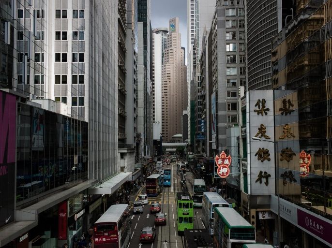 Vehicles are seen on a street lined up by high buildings in the financial district of Hong Kong on July 27, 2015. Hong Kong stocks closed 3.09 percent lower following a sharp drop in share prices in mainland China on growing concerns about a slowdown in the world's second-largest economy. AFP PHOTO / Philippe Lopez