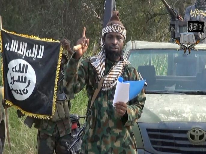 BOK08 - Kano, -, NIGERIA : (FILES) -- A file picture of a screengrab taken on October 2, 2014 from a video released by the Nigerian Islamist group Boko Haram and obtained by AFP shows Boko Haram leader, Abubakar Shekau gesturing as he delivers a speech. The leader of Nigeria's Boko Haram denied he had been killed or ousted as chief of the jihadist group in an audio recording released on August 15, 2015 attributed to him by security experts. In the eight-minute Hausa-language message, Abubakar Shekau rebuffed claims by Chadian leader Idriss Deby that he had been replaced and called the president a "hypocrite" and a "tyrant". AFP PHOTO / HO / BOKO HARAM