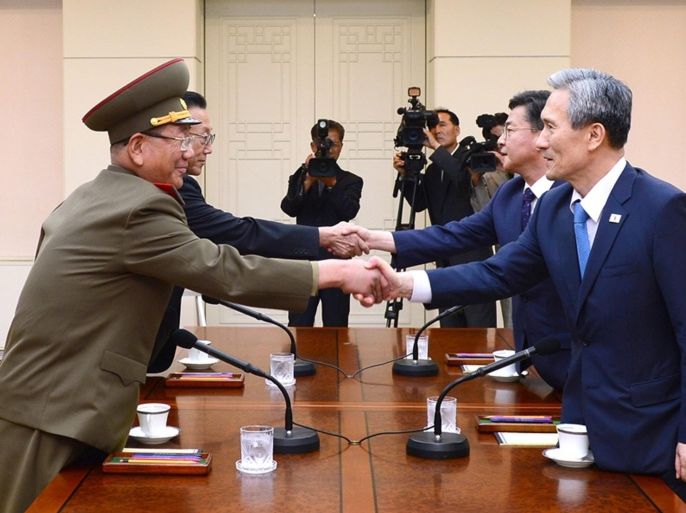 A handout picture provided by the South Korean Ministry shows (From R, counterclockwise) South Korean National Security Adviser Kim Kwan-jin, South Korean Unification Minister Hong Yong-pyo, Kim Yang-gon, the top North Korean official in charge of inter-Korean affairs, and Hwang Pyong-so, the North Korean military's top political officer, shake hands during the inter-Korean high-level talks at the truce village of Panmunjom inside the Demilitarized Zone, 22 August 2015. High-level teams from North and South Korea were set to meet at the truce village of Panmunjom on 22 August in an attempt to tamp down tensions following an exchange of gunfire this week that had let the North to threaten 'all-out war.' EPA/YONHAP / SOUTH KOREAN MINISTRY / HANDOUT