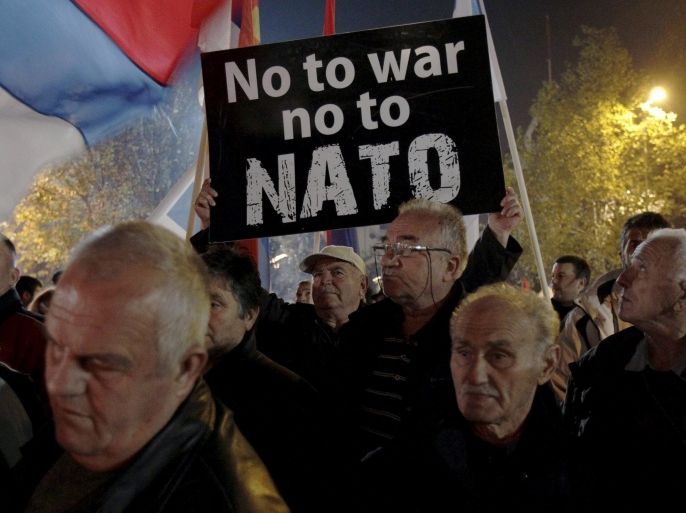 A demonstrator holds a sign during an anti-NATO protest in Podgorica, Montenegro, December 12, 2015. REUTERS/Stevo Vasiljevic