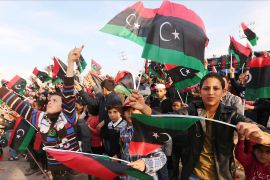 Libyans wave their national flags during a rally to celebrate the country's 64th independence anniversary at the Martyrs square in the capital Tripoli, on December 24, 2015. AFP PHOTO / MAHMUD TURKIA