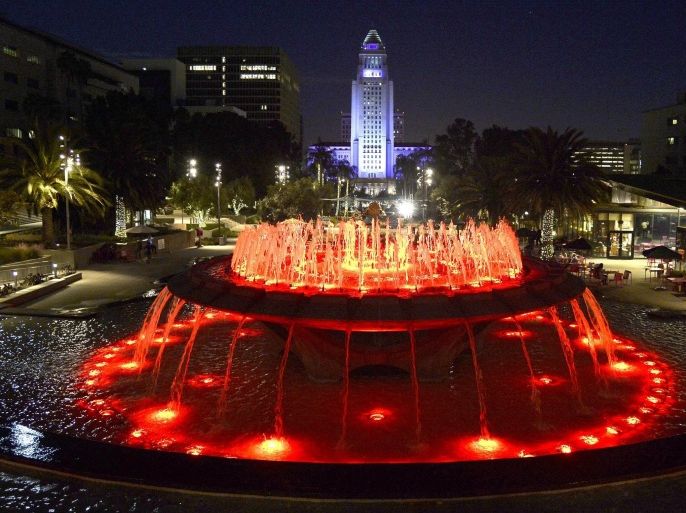 A fountain is illuminated by red lights at Grand Park as the Los Angeles City hall (back) is lit in blue, in downtown Los Angeles, California, USA, 25 October 2015. The City Hall has been bathed in blue light after the Los Angeles Dodgers baseball team made their play-offs. However, they were defeated by the New York Mets who now face the Kansas City Royals in the World Series.