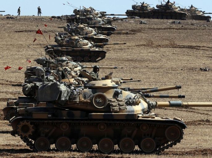 Turkish army tanks take up position on the Turkish-Syrian border near the southeastern town of Suruc in Sanliurfa province October 6, 2014. Outgunned Kurdish fighters vowed on Monday not to abandon their increasingly desperate efforts to defend the Syrian border town of Kobani from Islamic State militants pressing in from three sides and pounding them with heavy artillery. Despite the heavy fighting, which has seen mortars rain down on residential areas in Kobani and stray fire hit Turkish territory, a Reuters reporter saw around 30 people cross over from Turkey, apparently to help with defence of the town. REUTERS/Umit Bektas (TURKEY - Tags: MILITARY CONFLICT POLITICS)