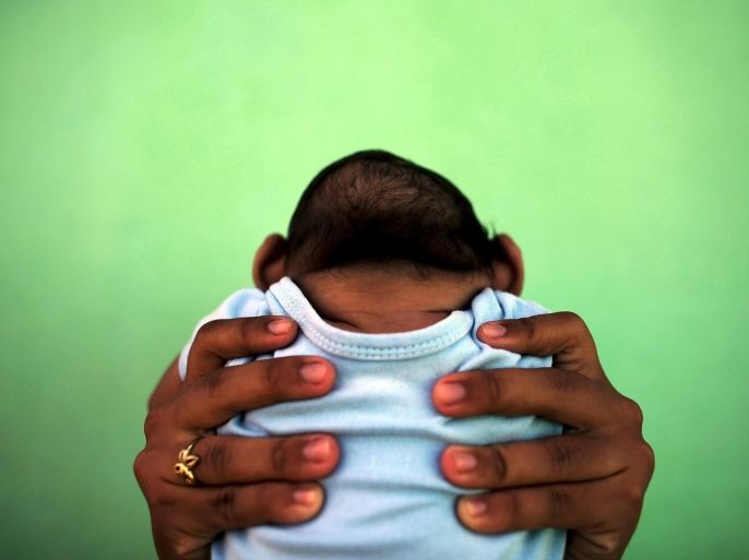 Jackeline, 26, holds her son who is 4-months old and born with microcephaly, in front of their house in Olinda, near Recife, Brazil, in this February 11, 2016 file photo. Evidence is building for the theory that Zika can cause newborn brain defects, and the World Health Organization is promising more answers in weeks, but nailing a definitive link will be neither simple nor swift. Picking apart numerous potential connections between mothers who show evidence of infection with the mosquito-borne virus and babies born with microcephaly, in which the head is abnormally small, will require precision and patience, specialists say. To match Insight HEALTH-ZIKA/MICROCEPHALY REUTERS/Nacho Doce/Files