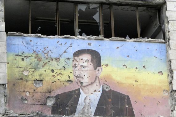 A picture of Syria's President Bashar al-Assad riddled with holes is seen on the facade of the police academy in Aleppo, after it was captured by Free Syrian Army fighters, March 4, 2013. On Sunday rebels said they captured a police academy on the outskirt of Aleppo, after days of fighting in which rebels killed 150 soldiers, while sustaining heavy casualties. REUTERS/Mahmoud Hassano (SYRIA - Tags: POLITICS CIVIL UNREST)