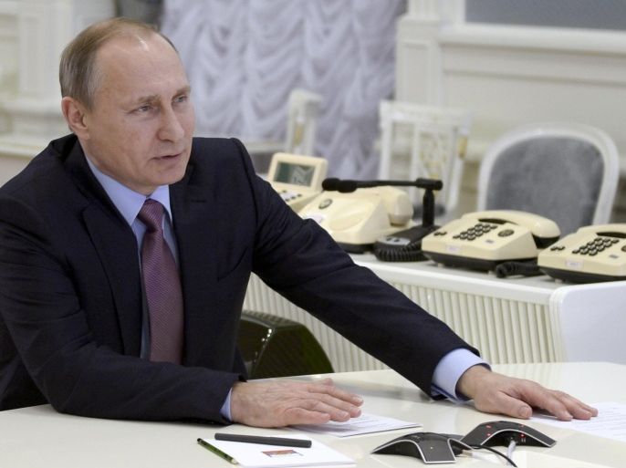 Russian President Vladimir Putin watches the opening of two new power units of the united Russian power system during a live video link from Moscow, Russia, Tuesday, Dec. 22, 2015. (Alexei Nikolsky/Sputnik, Kremlin Pool Photo via AP)