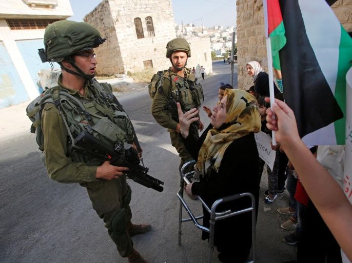 A Palestinian woman argues with an Israeli solider during a protest calling for the reopening of a closed street in the West Bank city of Hebron August 24, 2016. REUTERS/Mussa Qawasma