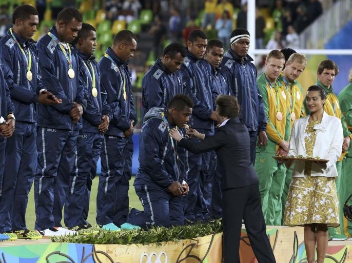 2016 Rio Olympics - Rugby - Men's Victory Ceremony - Deodoro Stadium - Rio de Janeiro, Brazil - 11/08/2016. Britain's Princess Anne awards a gold medal to a member of team Fiji on his knees during the victory ceremony. REUTERS/Alessandro Bianchi (BRAZIL - Tags: SPORT OLYMPICS SPORT RUGBY ROYALS) FOR EDITORIAL USE ONLY. NOT FOR SALE FOR MARKETING OR ADVERTISING CAMPAIGNS.