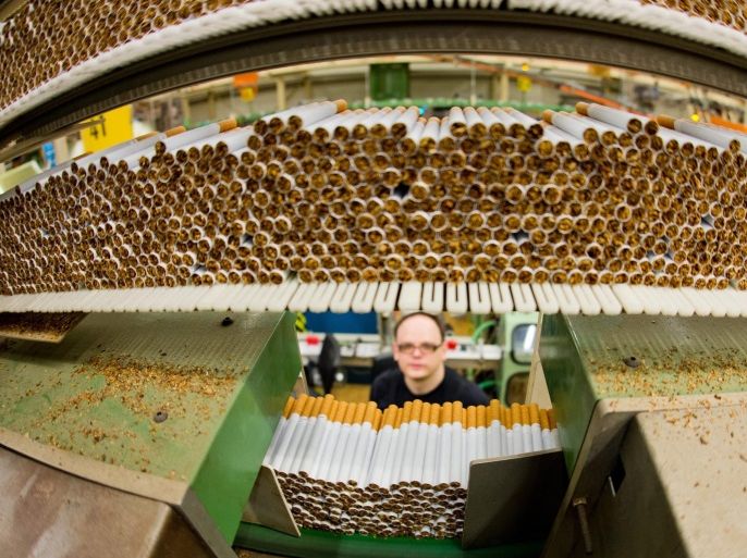 (FILE) A file photo dated 31 October 2013 showing an employee standing behind 'West' cigarettes in the Reemtsma cigarette factory, a wholly owned subsidiary of the Imperial Tobacco Group PLC., in Langenhagen, Germany. About 700 employees in the factory produce more than 30 billion cigarettes annually, which are exported to over 100 countries. Imperial Tobacco Group PLC. released their 2016 half year results for the six months ended in March 2016 on 04 May 2016, saying