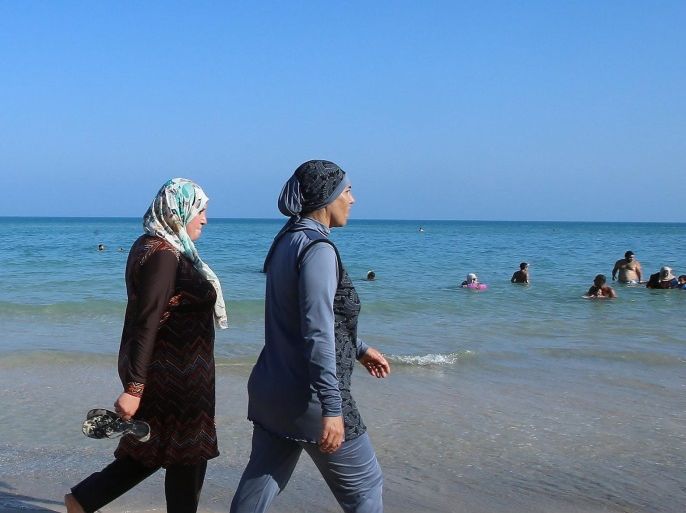 Tunisian women wearing a 'burkini' walk at beach Bizerte, north-eastern Tunis, Tunisia, 28 August 2016.