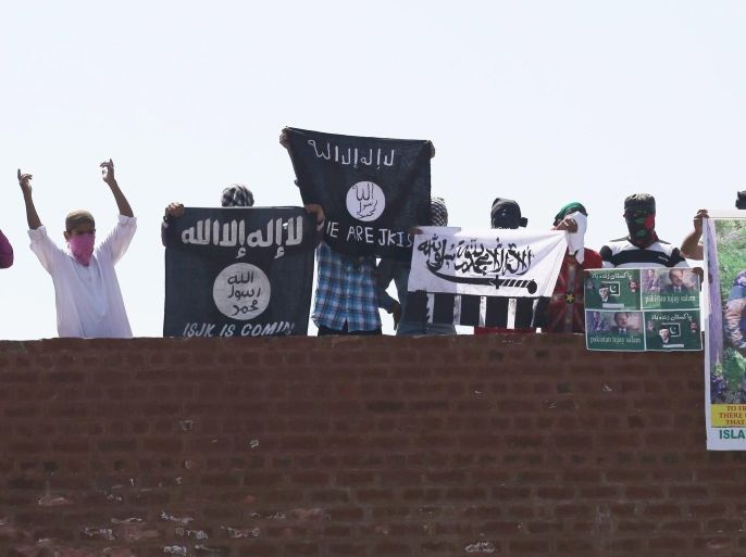 Masked Kashmiri youth hold (R to L) the flag of the group calling themselves Islamic State (IS), Lashkar-e-Toiba, and posters of Pakistan founder Ali Mohammad Jinnah and former ISI chief Hamid Gul and local militant commander of Hizbul Mujahideen Burhan during a protest outside the Jamia Masjid (mosque) in downtown Srinagar, the summer capital of Indian Kashmir, 28 August 2015. According to local reports the flags of extremist groups have become a common sight during Friday prayers.