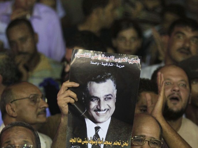 A protester holds up a poster with an image of former Egypt president Gamal Abdel Nasser during the anniversary of the 1952 Egyptian revolution at Tahrir Square in Cairo July 23, 2012. REUTERS/Mohamed Abd El Ghany (EGYPT - Tags: POLITICS CIVIL UNREST)