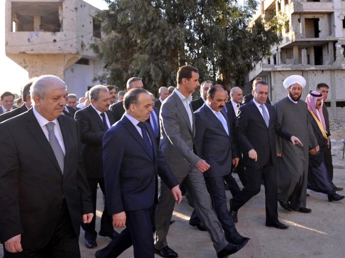 A photo released by the official Syrian Arab News Agency (SANA) on 12 September 2016 shows Syrian President Bashar al-Assad (C) touring Daraya city after performing Eid al-Adha (Feast of the Sacrifice) prayers at the city's Saad Ibn Muaz Mosque in Daraya, outside Damascus, 12 September 2016. Others are not identified. More than 3,000 civilians and some 800 rebel fighters have been evacuated fom the town on 25 August, under the conditions of a humanitarian accord betwe