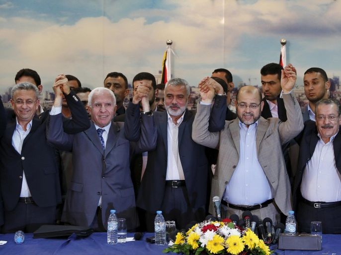 Senior Fatah official Azzam al-Ahmed (2nd L), senior Hamas leader Ismail Haniyeh (3rd L) and senior Hamas leader Moussa Abu Marzouk (4th L) hold their hands after announcing a reconciliation agreement in Gaza City in this April 23, 2014 file photo. In recent weeks, a flurry of envoys has beaten a path to Gaza's door: representatives from Qatar, Turkey, the United Nations, the European Union and former U.S. president Jimmy Carter have all visited or tried to visit. Yet