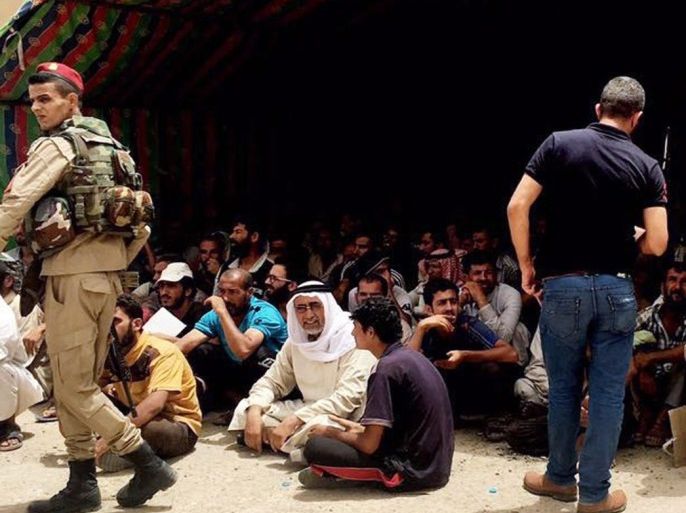 Iraqi policemen stand guard near dozens of men who were arrested by Iraqi forces during a military operation in northern Fallujah city, west of Iraq, 09 June 2016. Iraqi security forces detained dozens of men from the north and east of Fallujah city for interrogation on suspicion of belonging to the Islamic state group (IS) during a military operation launched a week ago to take back the city of Fallujah, located around 50 kilometers east of Baghdad in the western province of al-Anbar, from the hands of the Islamic State (IS).