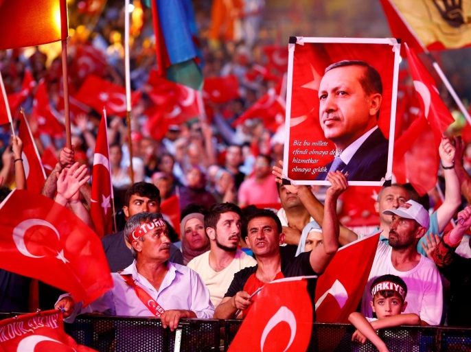 Supporters of Turkish President Recep Tayyip Erdogan wave national flags as they listen to him through a giant screen in Istanbul's Taksim Square, Turkey, August 10, 2016. REUTERS/Osman Orsal/File Photo
