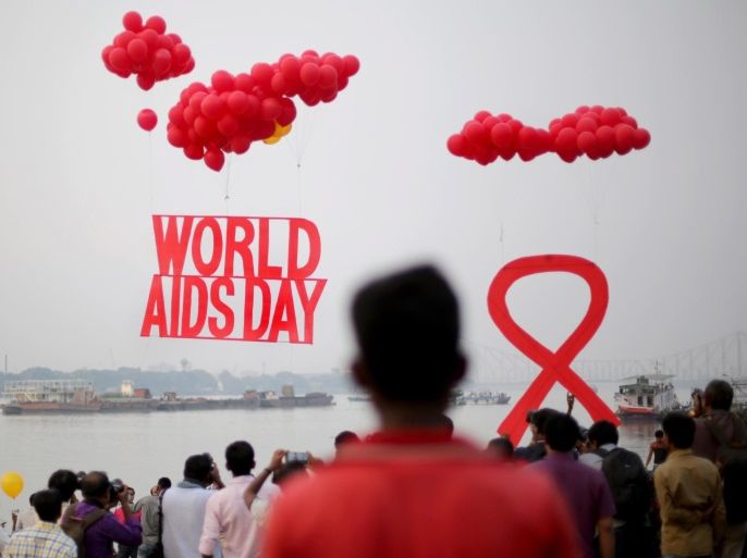 Activists hold the symolic 'Red Ribbon' as balloons are released during an AIDS awareness campaign on the eve of World AIDS Day near Howrah Bridge, on the bank of river Gangesin Calcutta, eastern India, 30 November 2016. World AIDS Day is observed every 01 December with calls from international health and advocacy organizations for the public to get involved in programs for awareness, prevention and treatment of HIV/AIDS.