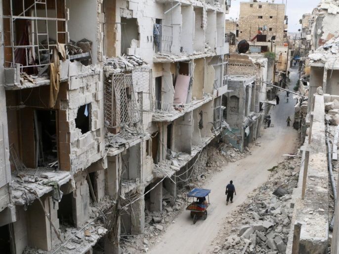 Residents walk near damaged buildings in the rebel held area of Old Aleppo, Syria May 5, 2016. REUTERS/Abdalrhman Ismail/File Photo