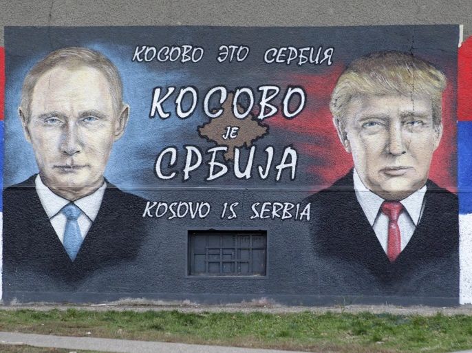 A man walks past a mural depicting Russian President Vladimir Putin (L) and US President-elect Donald Trump (R) in Belgrade, Serbia, 5 December 2016. The message on the mural reads in Serbian, Russian and English 'Kosovo is Serbia'.
