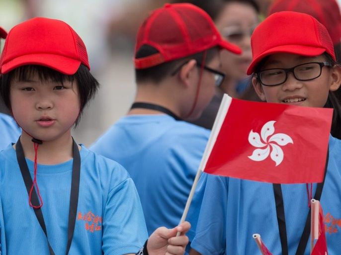 Schoolchildren wave Chinese and Hong Kong flags while waiting for the Rio Olympic Games Mainland Olympians delegation on the apron of Hong Kong International Airport in Hong Kong, China, 27 August 2016. China’s Olympic medallists landed in Hong Kong marking the start of a three-day visit to the city.