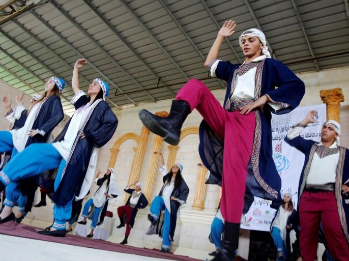 Palestinians perform a traditional dance during a fashion show in celebration of Palestinian Traditional Dress and Heritage Day at Haddad village near the West Bank city of Jenin, July 25, 2016. REUTERS/Abed Omar Qusini