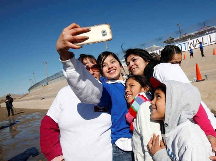 Relatives separated by deportation and immigration pose for a selfie at the border during a reunification event named "#Hugs Not Walls" at the banks of the Rio Bravo, a natural border between U.S. and Mexico, January 28, 2017. REUTERS/Jose Luis Gonzalez