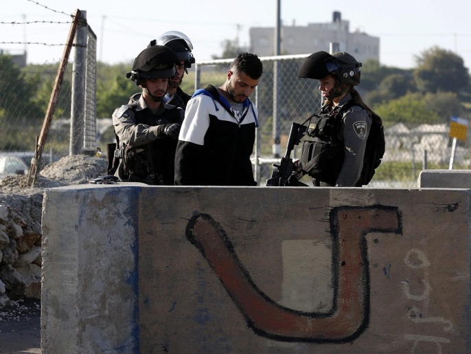 Israeli border police order an arrested Palestinian to sit down on the ground while checking his identity at a checkpoint in Beit Enoon, near the West Bank city of Hebron, 04 April 2016. The man reportedly was arrested within the usual security measures taken in the region by the Israeli forces.