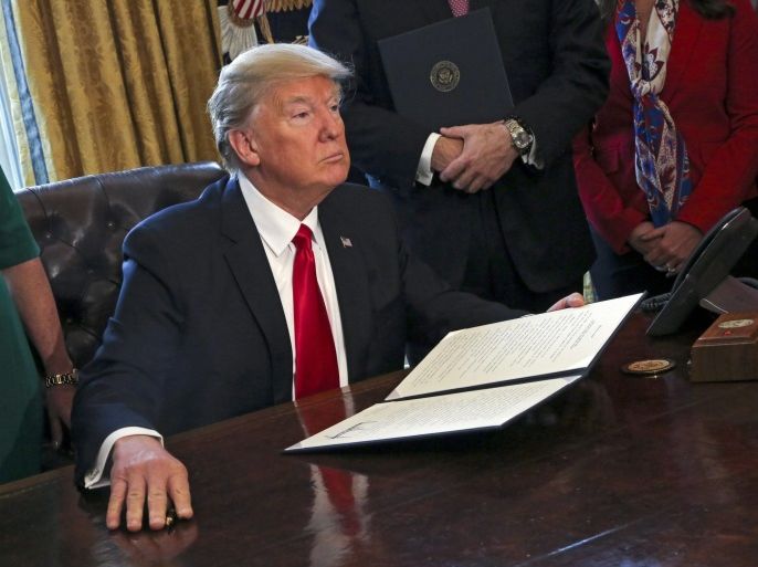 US President Donald J. Trump poses after signing an executive order in the Oval Office of the White House, in Washington, DC, USA, 03 February 2017. Trump signed several executive orders including an order to review the Dodd-Frank Wall Street to roll back financial regulations of the Obama era.