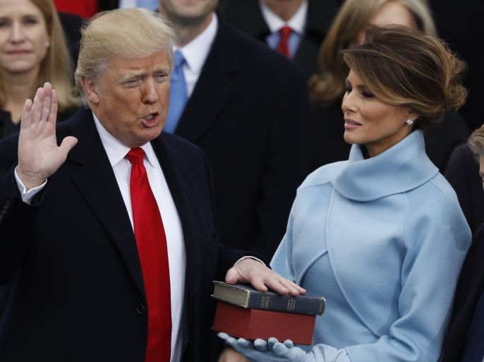 Donald Trump takes the oath of office as his wife Melania holds a bible during his inauguration as the 45th president of the United States on the West front of the U.S. Capitol in Washington, U.S., January 20, 2017. REUTERS/Lucy Nicholson