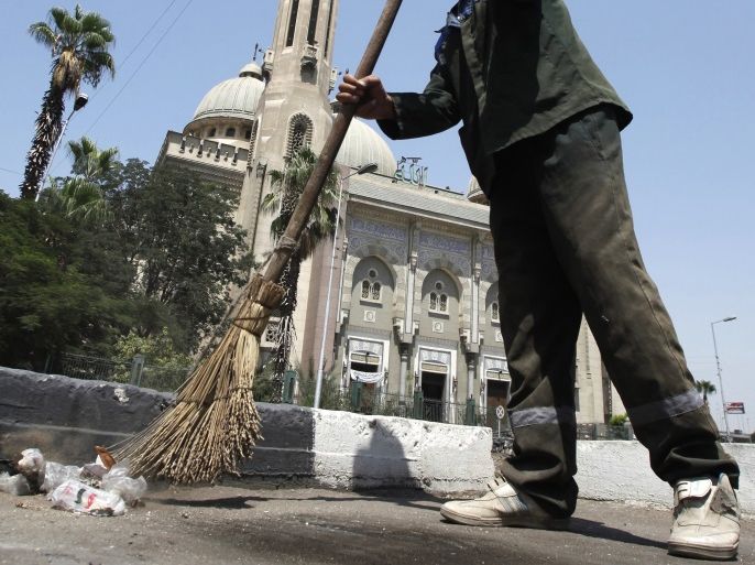 A man clears the ground in front of El Nour Mosque at El Abbassia Square after clashes last night between demonstrators with loyalists of the ruling military council near the defence ministry, the headquarters of the Supreme Council of the Armed Forces, in Cairo July 24, 2011. Scores of people were injured in Cairo on Saturday when thousands of demonstrators fought opponents with stones on their march to the Defense Ministry to urge their military rulers to speed up reforms, witnesses said. REUTERS/Mohamed Abd El-Ghany (EGYPT - Tags: CIVIL UNREST POLITICS)