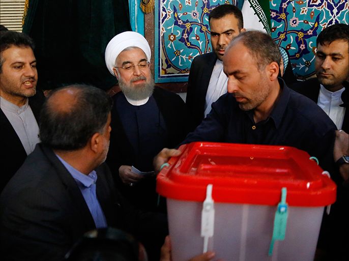epa05973364 Iranian president Hassan Rouhani (C) casts his ballot in Ershad Mosque polling station during the Iranian presidential elections in Tehran, Iran, 19 May 2017. Out of the candidates, the race is tightest between frontrunners Iranian current president Hassan Rouhani and conservative presidential candidate Ebrahim Raisi. EPA/ABEDIN TAHERKENAREH