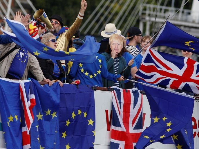 Anti-Brexit, pro-European Union Remain supporters wave flags as they travel up and down the River Thames, outside the Houses of Parliament, in London, Britain August 19, 2017. REUTERS/Luke MacGregor
