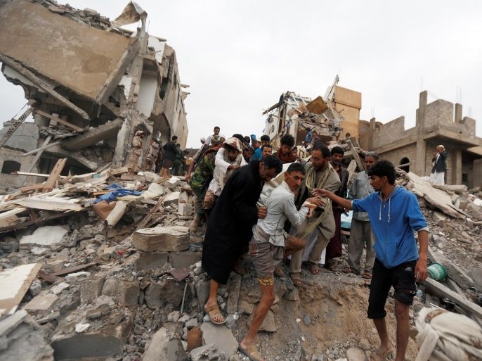 People carry the body of a woman they recovered from under the rubble of a house destroyed by a Saudi-led air strike in Sanaa, Yemen August 25, 2017. REUTERS/Khaled Abdullah