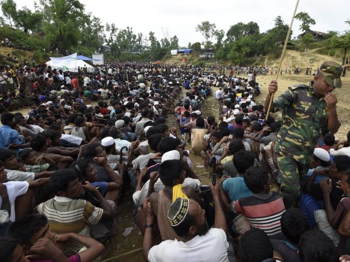 Rohingya Muslim refugees wait as food is distributed by the Bangladeshi army at Balukhali refugee camp near Gumdhum on September 26, 2017.Bangladesh has eased restrictions on aid groups working in refugee camps and sought $250 million from the World Bank to fund emergency relief, officials said September 26, after an influx of more than 435,000 Rohingya Muslims from Myanmar has overwhelmed its border area. The government NGO Affairs Bureau cleared 30 local and internati