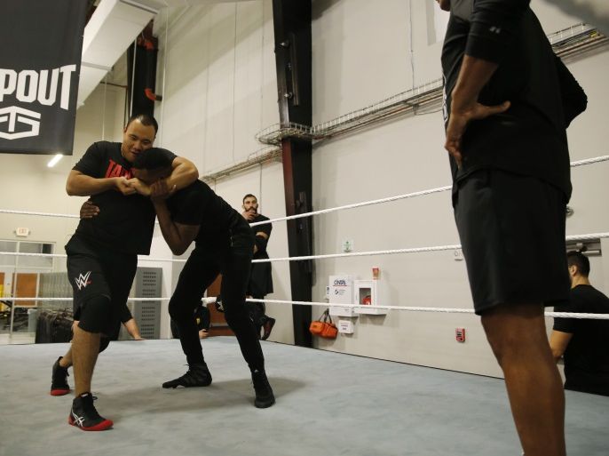 WWE wrestler Bin Wang of China puts a headlock on another development wrestler during ring training at the WWE Performance Center in Azalea Park, Florida, December 1, 2016. REUTERS/Scott Audette
