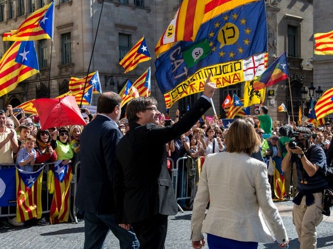 Catalan regional vice-president and chief of Economy and Finance, Oriol Junqueras (L), President of the Catalan Government Carles Puigdemont (C) and president of the Catalan parliament Carme Forcadell (R) arrive during a demonstration to support Catalan pro-referendum mayors on September 16, 2017 in Barcelona. More than 700 of the 948 mayors of Catalonia, threatened with judicial inquiries for supporting a referendum on self-determination banned by Spanish justice, shou