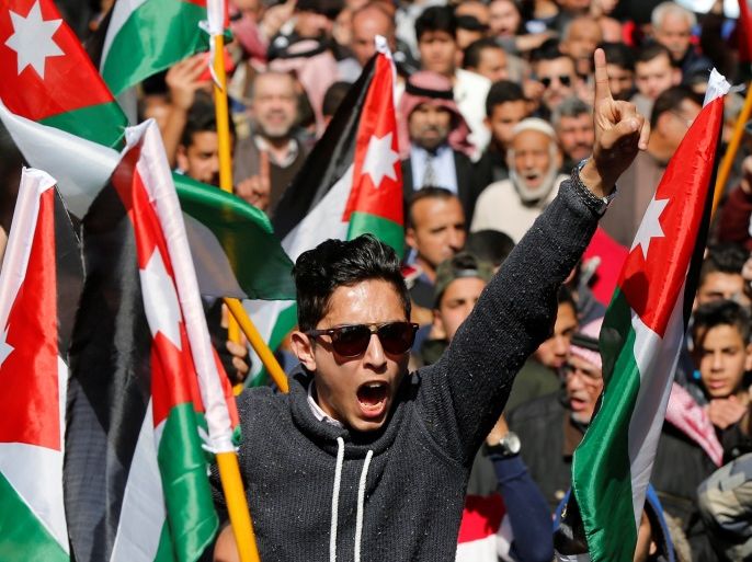Protesters from the Islamic Action Front and others hold Jordanian national flags and chant slogans during a protest against rising prices and the imposition of more taxes, after the Friday prayer in Amman, Jordan, February 24, 2017. REUTERS/Muhammad Hamed