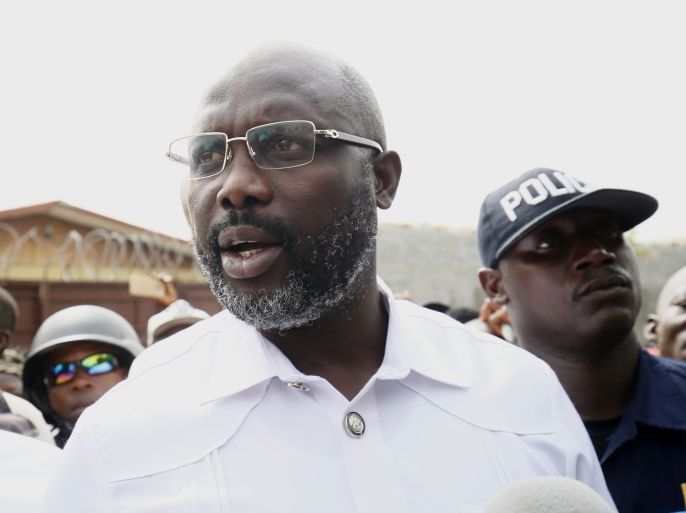 epa06405955 Liberian presidential candidate for the Coalition for Democratic Change (CDC), George Weah (C) leaves a polling station after casting his ballot in presidential elections run-off in Monrovia, Liberia, 26 December 2017.
